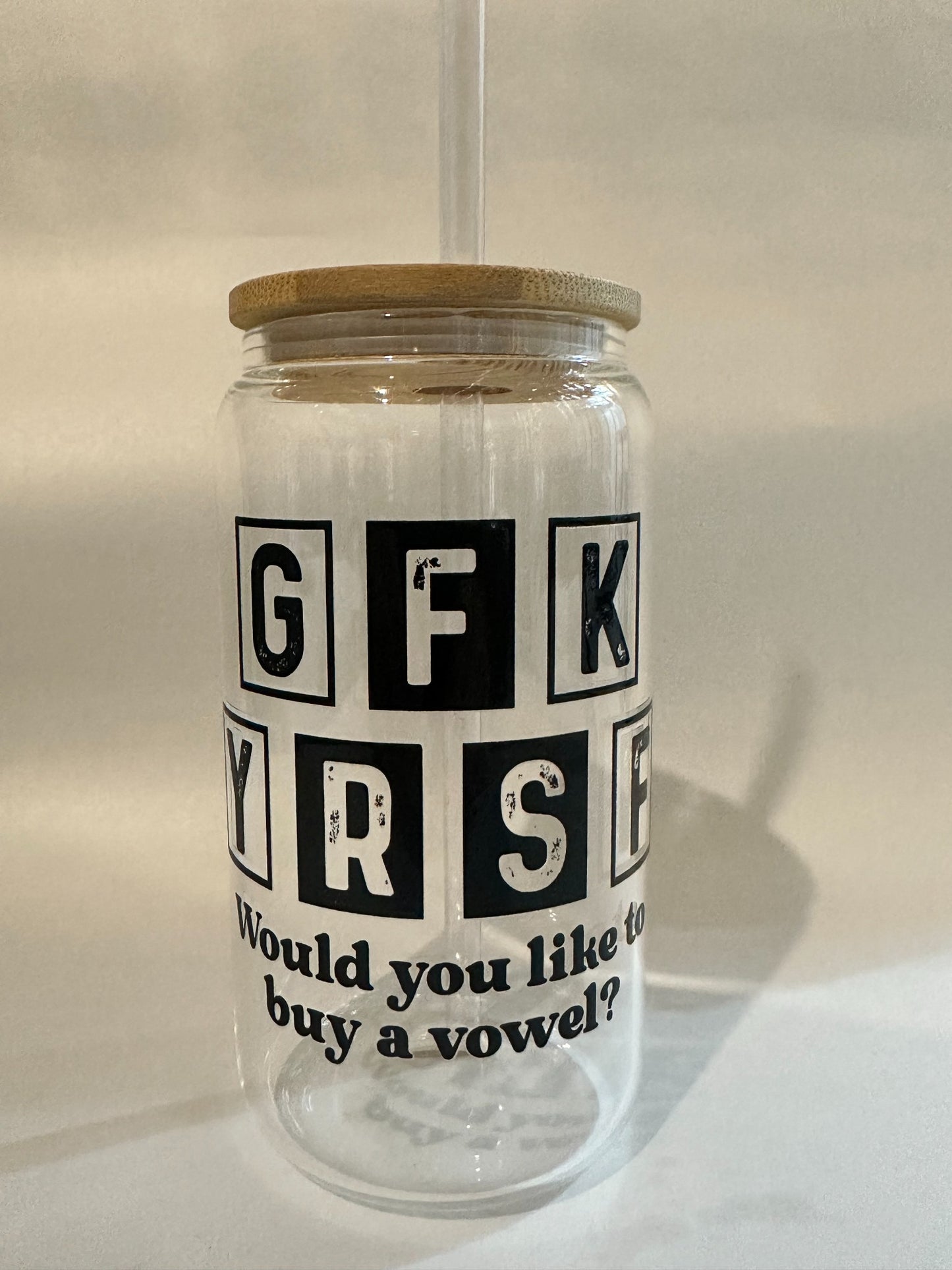 Front angle of Libby glass showing the full phrase “Would you like to buy a vowel?” with bamboo lid and straw.
