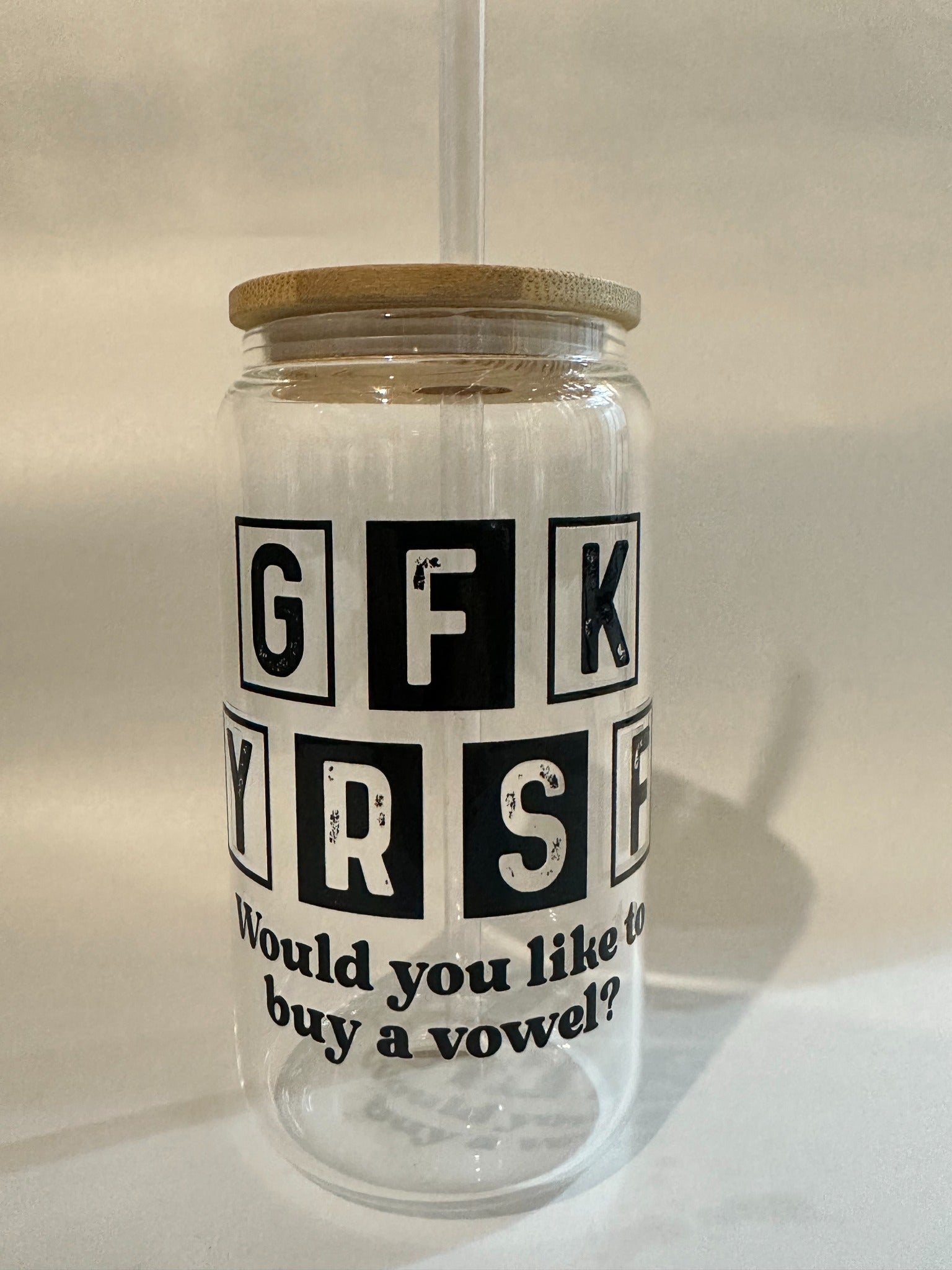 Front angle of Libby glass showing the full phrase “Would you like to buy a vowel?” with bamboo lid and straw.